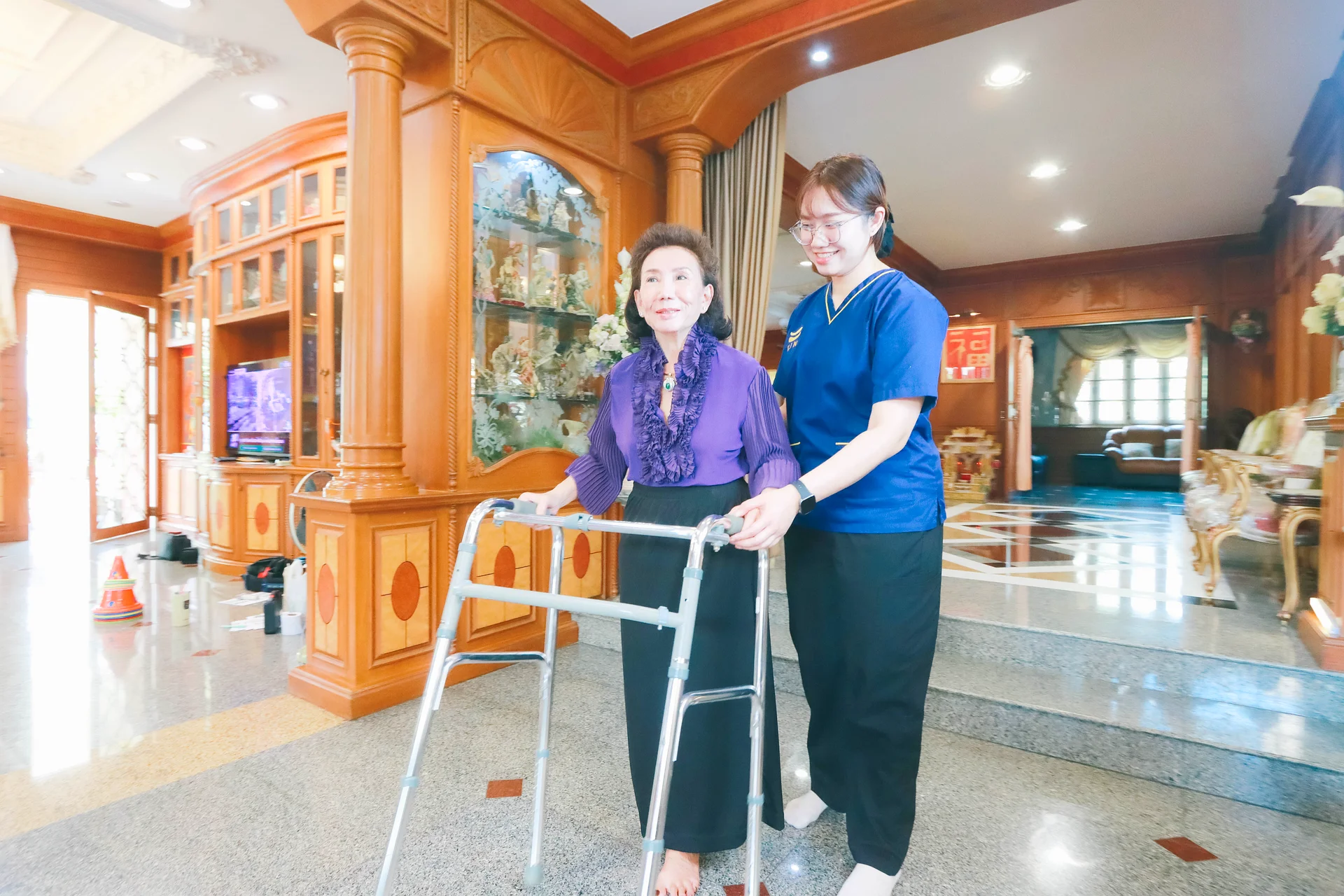 Stroke patient practising walking with a walker under the supervision of a KIN physical therapist